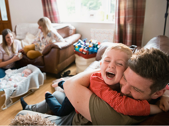Man and child hugging on a sofa