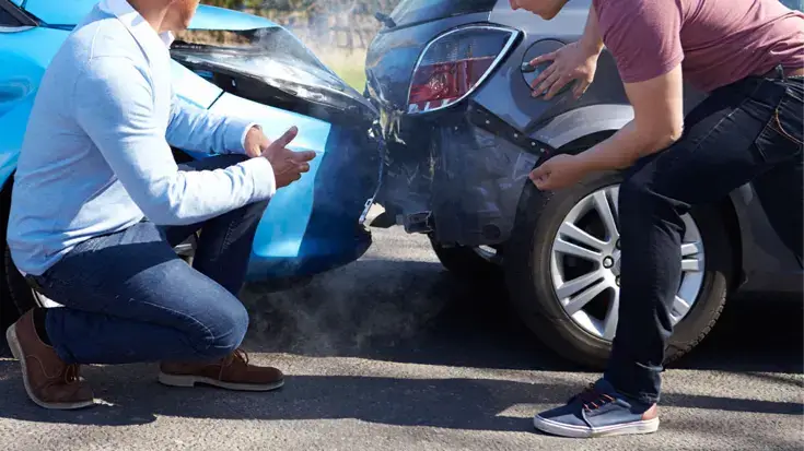 Two people discussing damage following a car accident